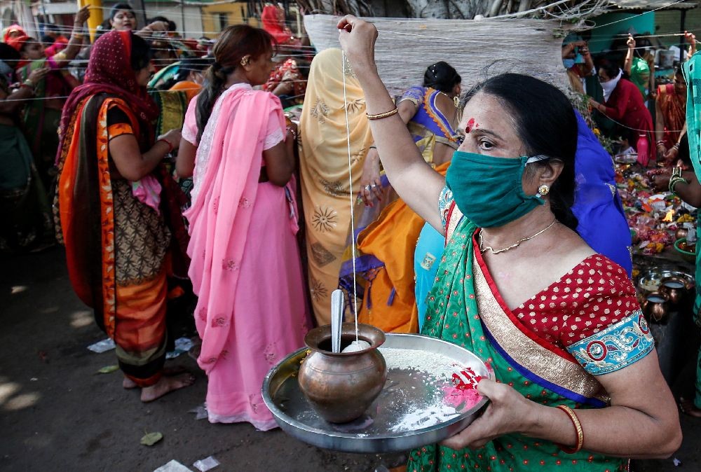 A Hindu woman wearing a protective mask ties a cotton thread around a Banyan tree on the occasion of "Vat Savitri festival", which is celebrated on a full moon day, when married women fast and pray for their husbands' health and longevity, after some restrictions were lifted during an extended nationwide lockdown to slow the spread of the coronavirus disease (COVID-19), in Ahmedabad, India, June 5, 2020. REUTERS/Amit Dave